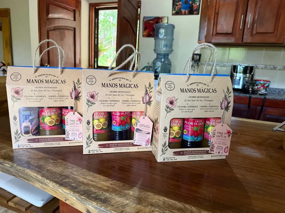 Tres cajas de regalo de Manos Mágicas sobre una mesa de madera